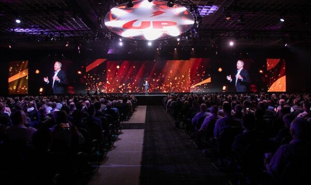 A man speaking at the crowd in a conference