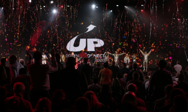 An event hall with audience cheering while confetti falls