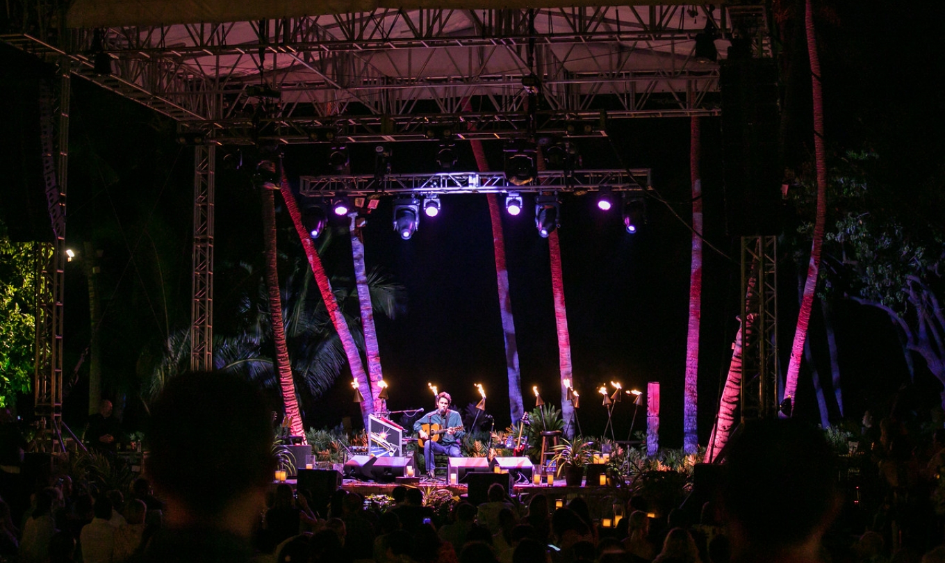 Man singing into the microphone and playing the guitar