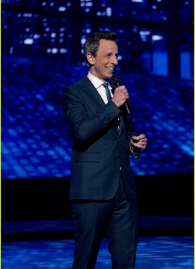 A man in a suit giving a speech at a conference