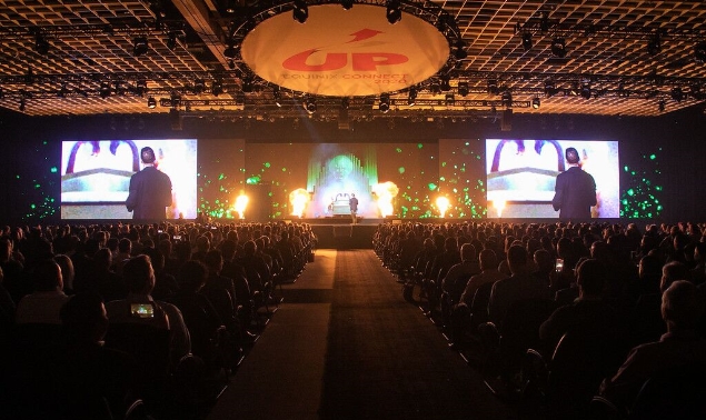 A man in a suit giving a speech at a conference