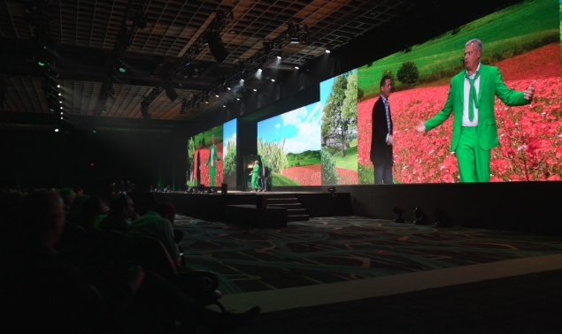 A presentation with two man wearing black and green jacket
