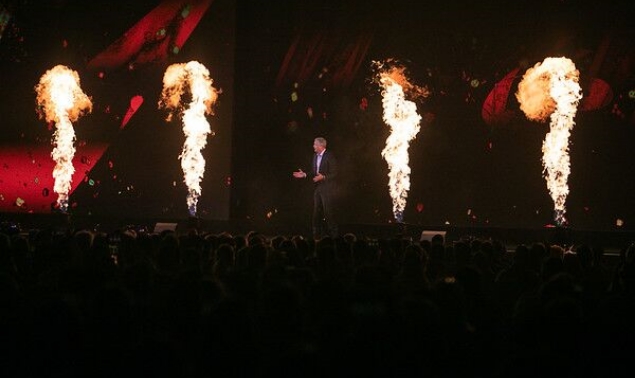 A man in a suit giving a speech at a conference